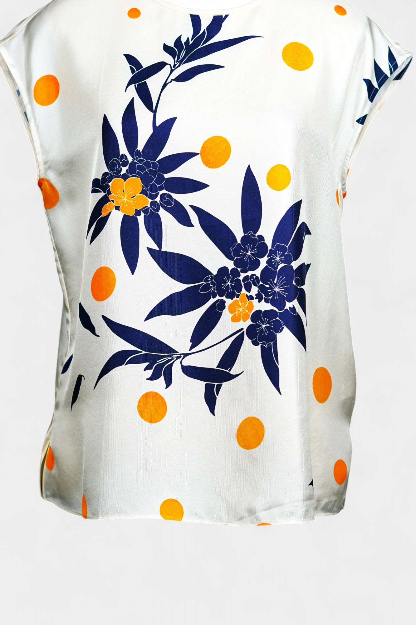 Cream silk sleeveless top featuring blue floral patterns and orange polka dots
