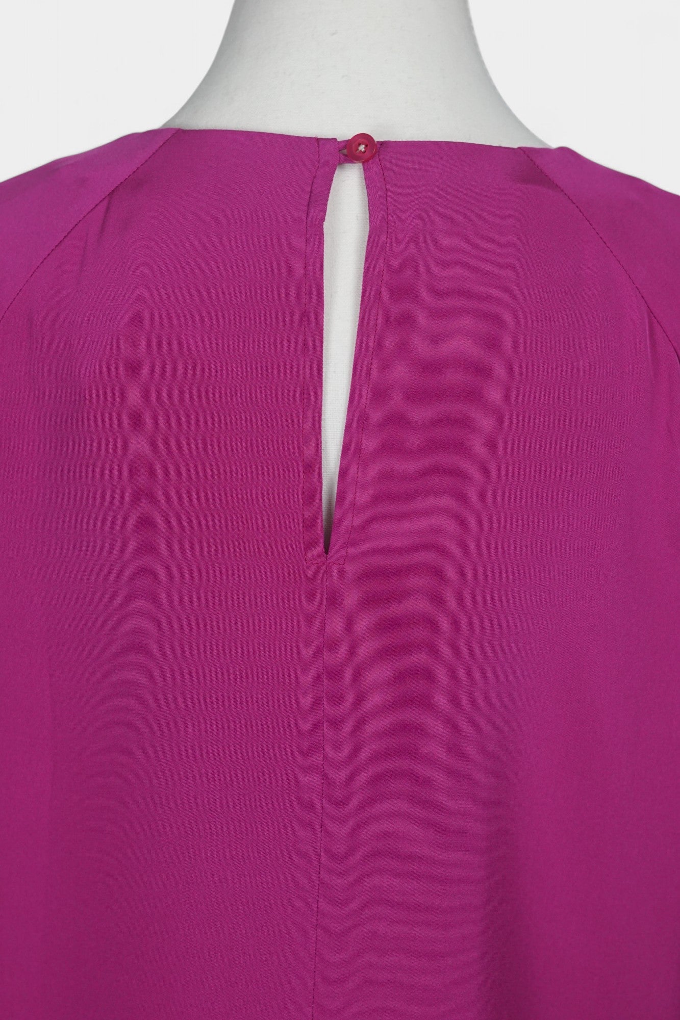 Women's short-sleeve magenta silk top with a round neck and raglan sleeves on a mannequin.
