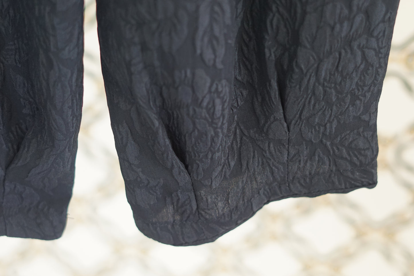 Black textured silk lantern pants with high elastic waistband and tapered ankles