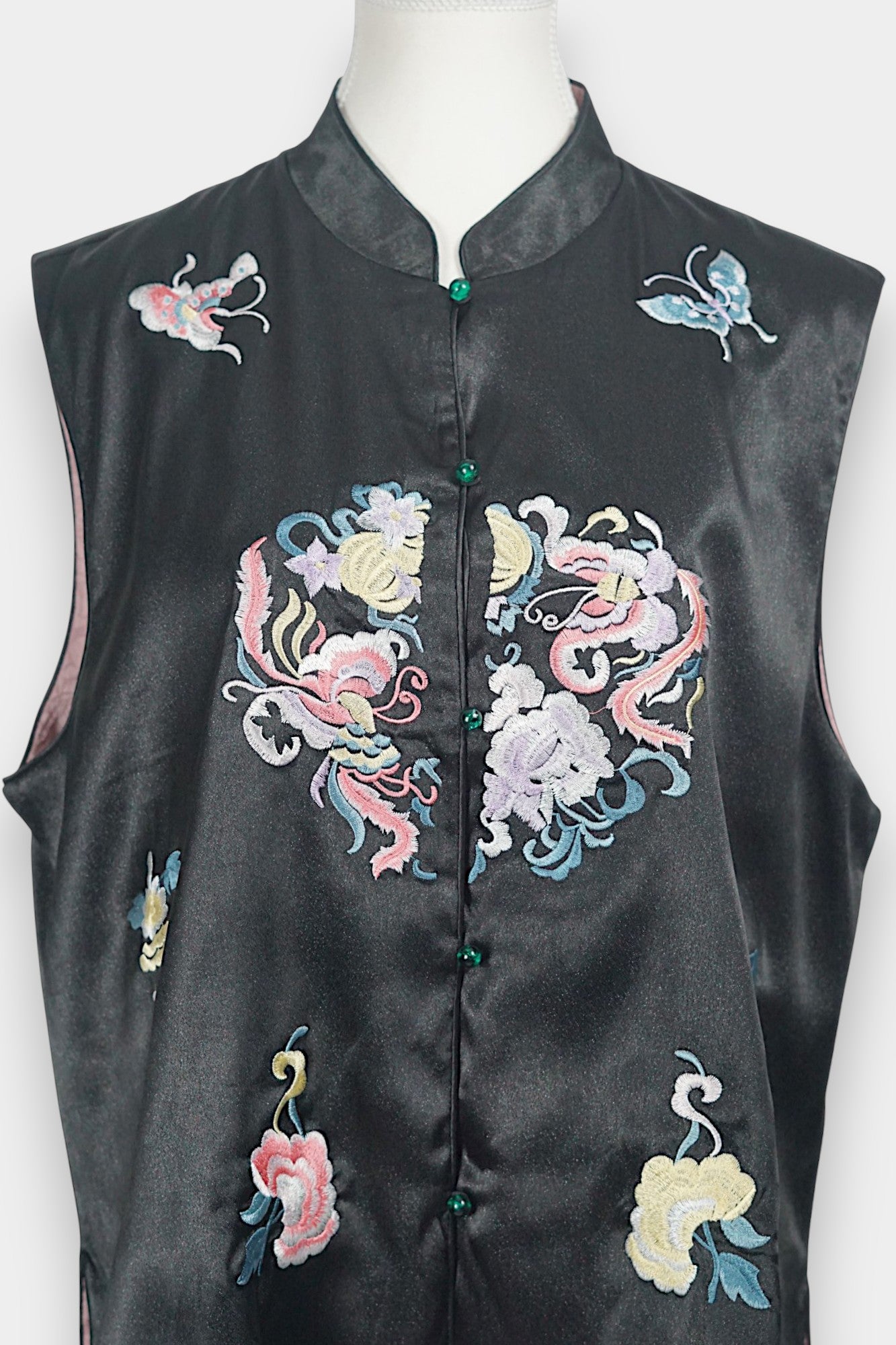 Traditional mandarin collar vest in black silk, adorned with pastel embroidered motifs of butterflies and mythical creatures
