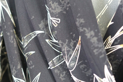 Women's black Gambiered Guangdong Gauze wrap dress with white bamboo leaf print and tie-cuff sleeves.