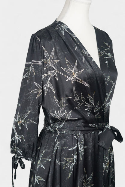 Women's black Gambiered Guangdong Gauze wrap dress with white bamboo leaf print and tie-cuff sleeves.