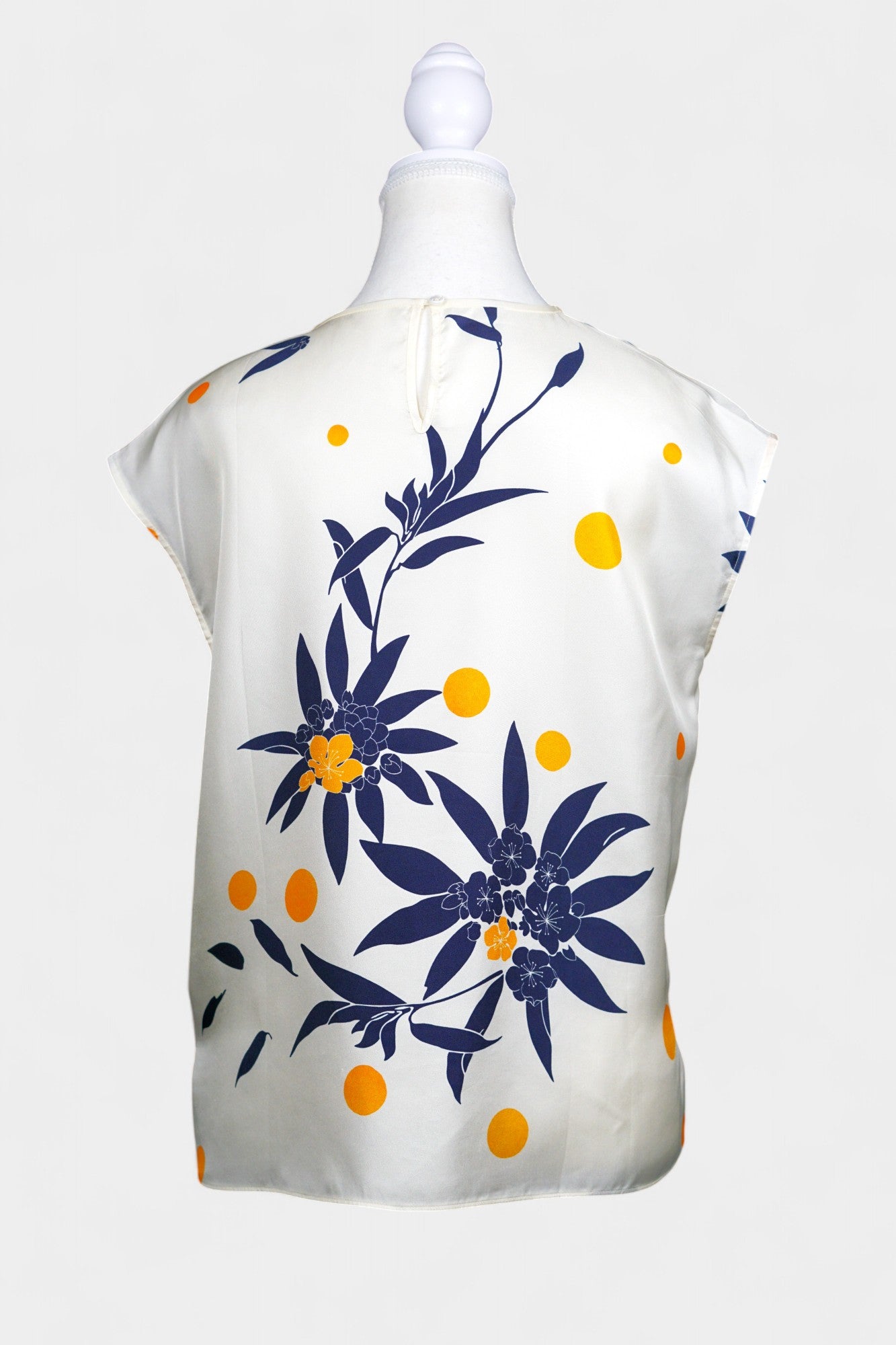 Cream silk sleeveless top featuring blue floral patterns and orange polka dots