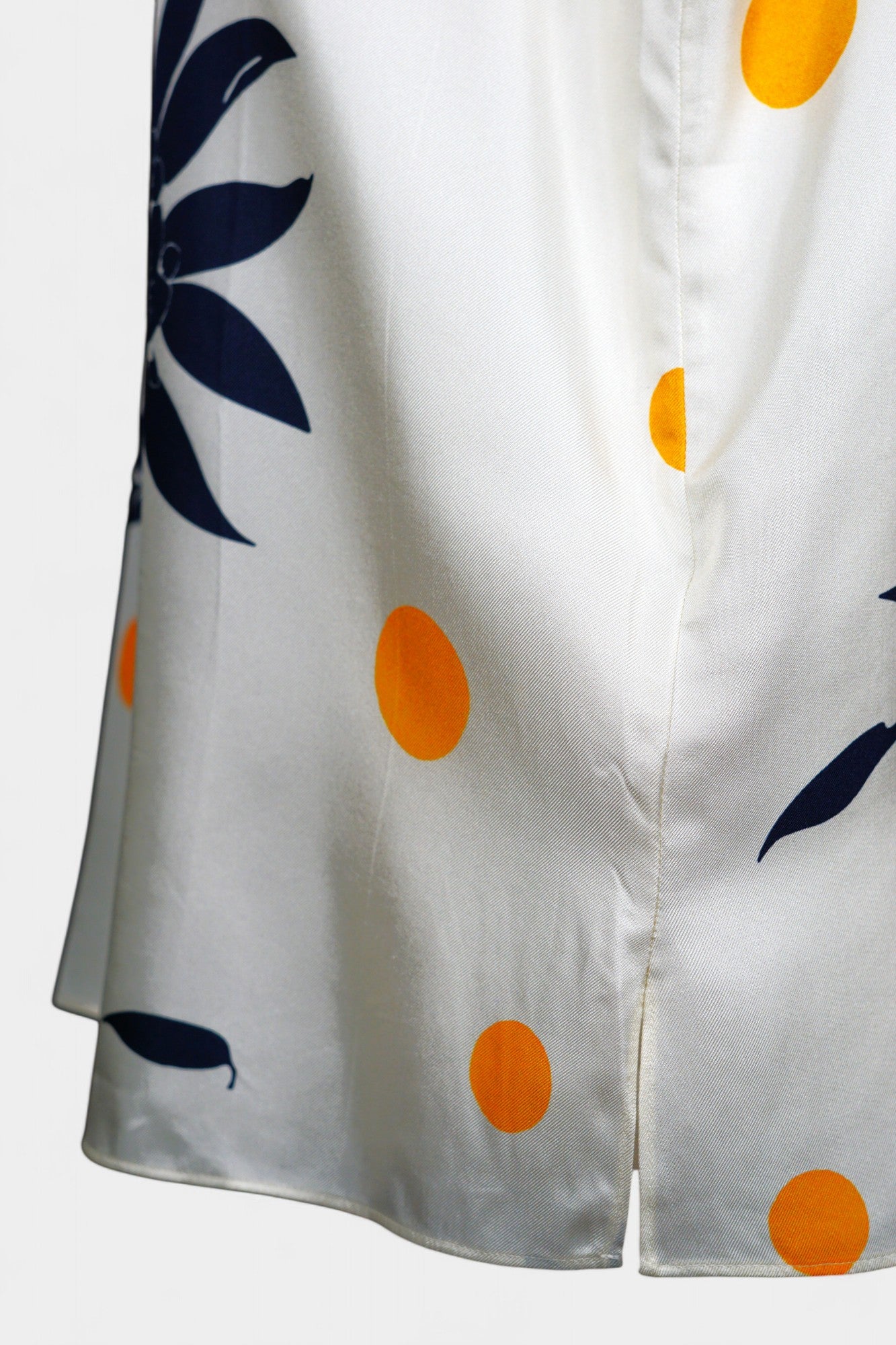 Cream silk sleeveless top featuring blue floral patterns and orange polka dots