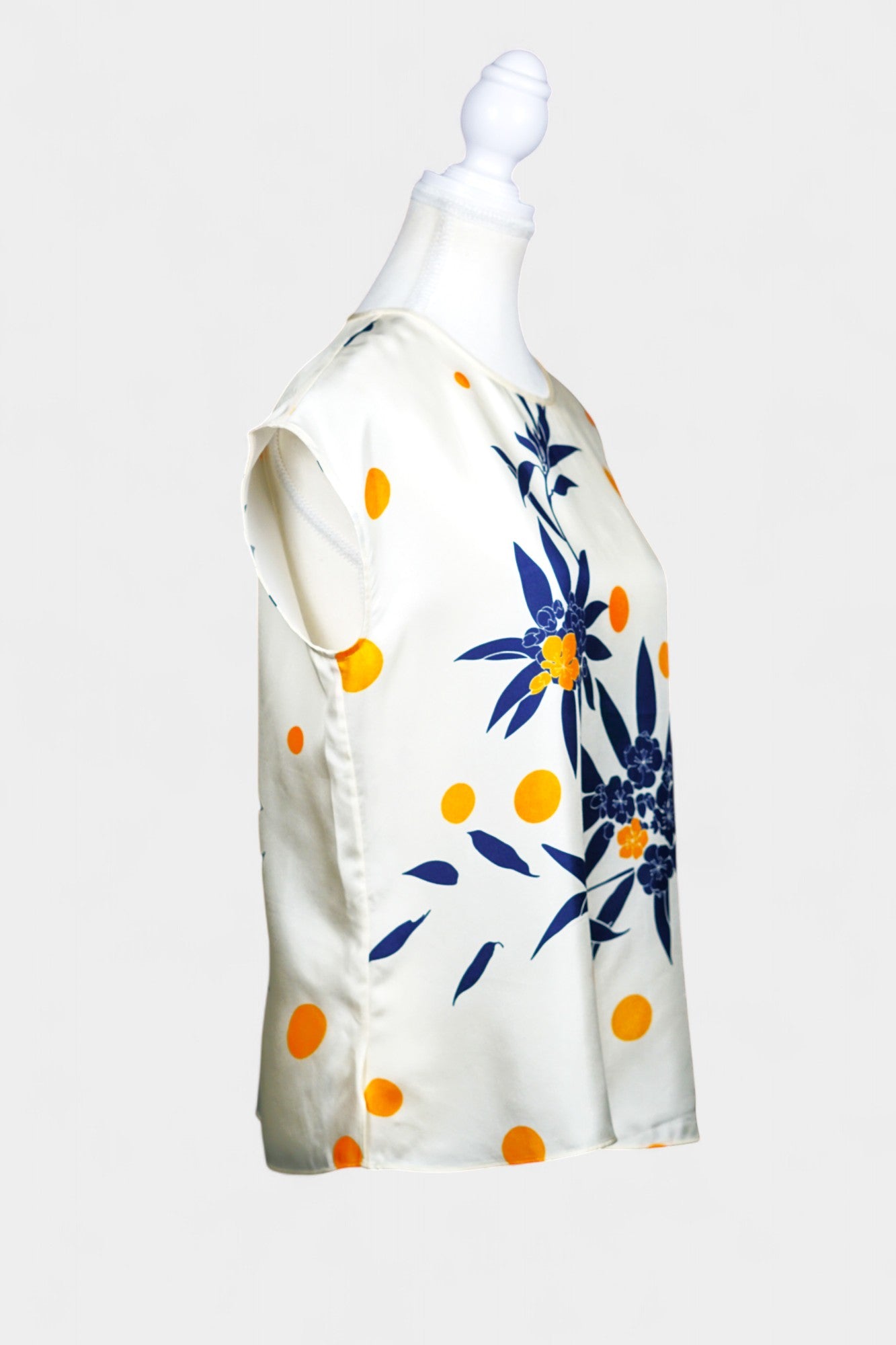 Cream silk sleeveless top featuring blue floral patterns and orange polka dots