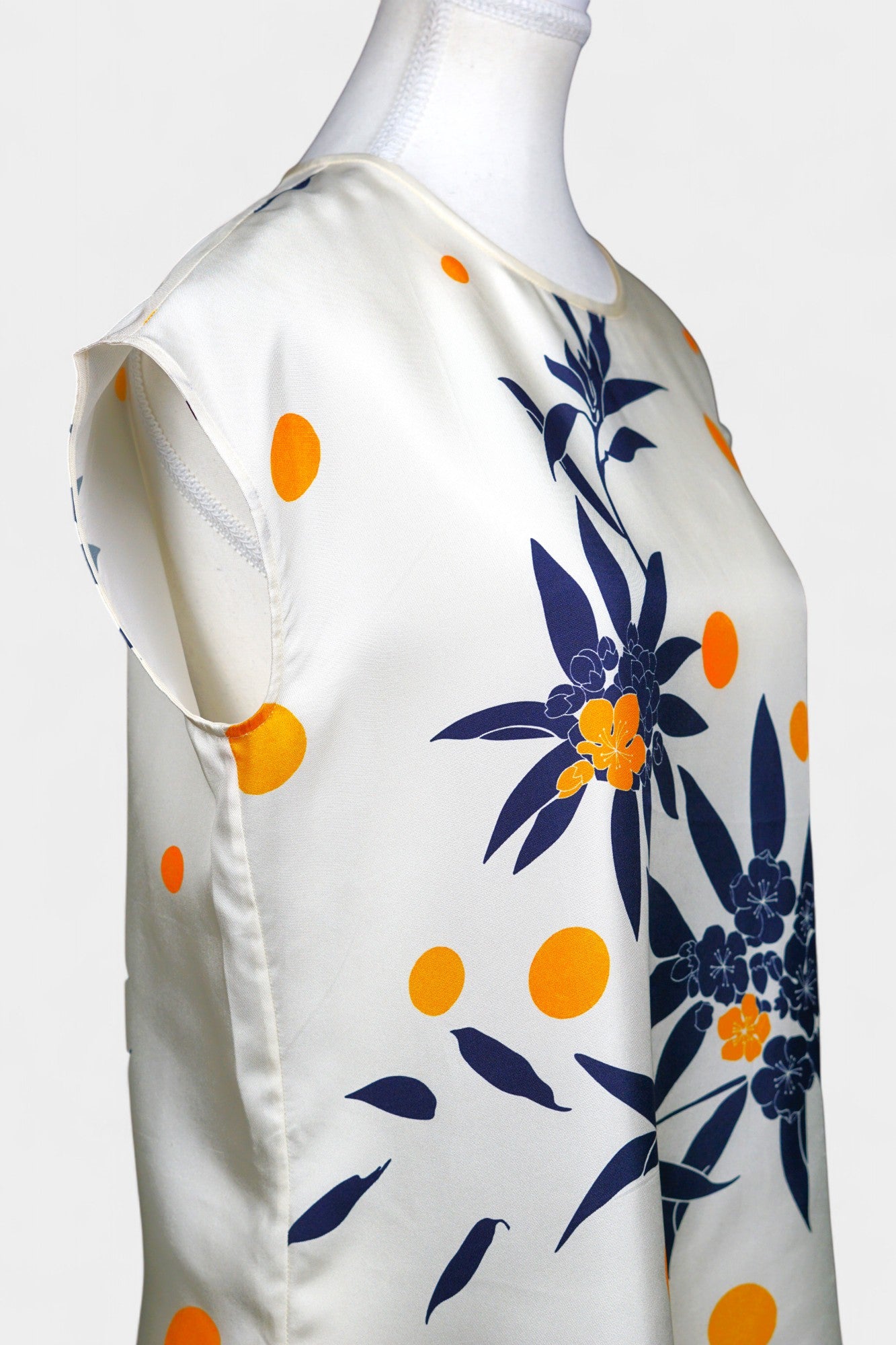 Cream silk sleeveless top featuring blue floral patterns and orange polka dots