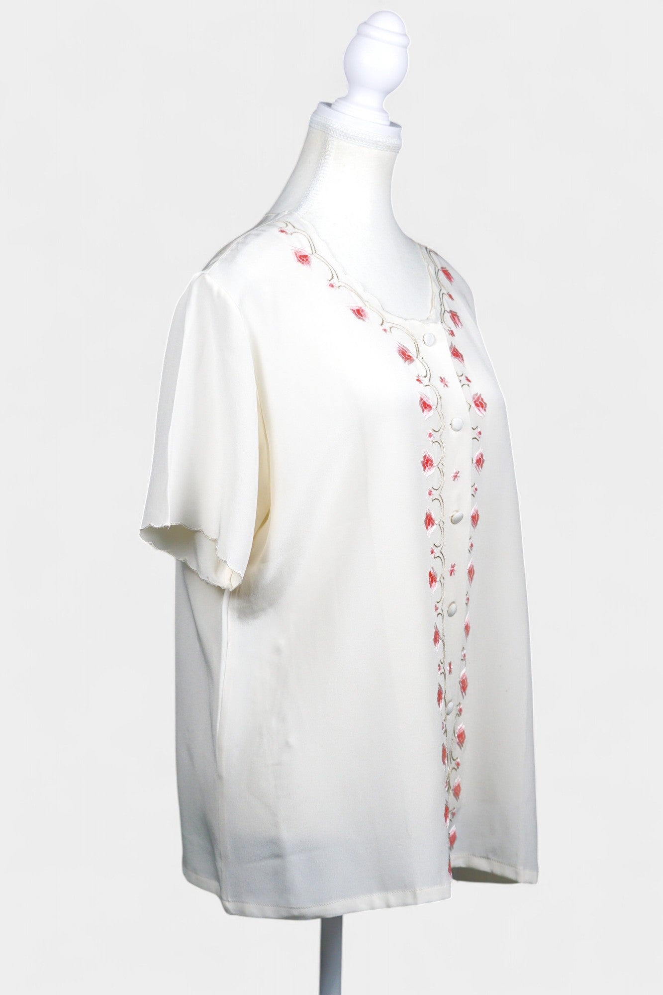 Cream silk short-sleeve blouse featuring pink floral embroidery and scalloped edges