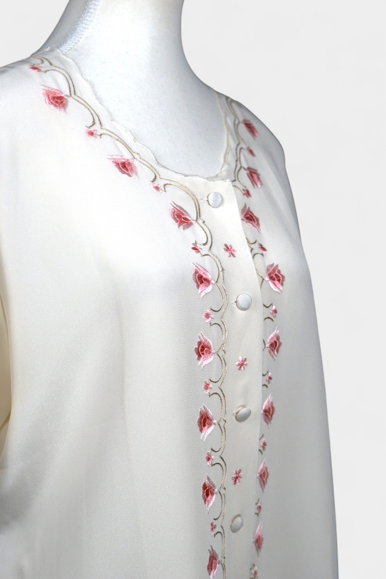 Cream silk short-sleeve blouse featuring pink floral embroidery and scalloped edges