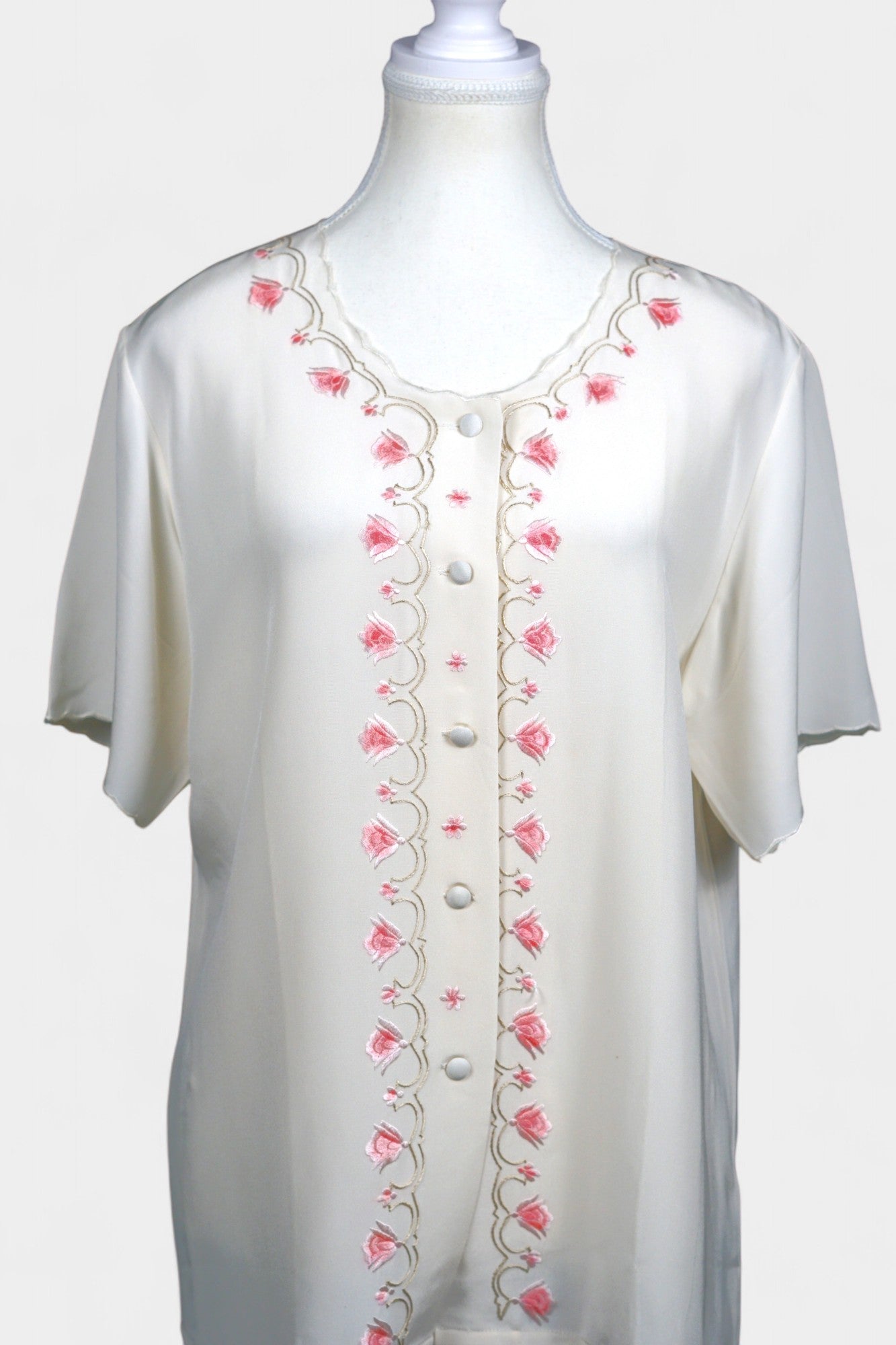 Cream silk short-sleeve blouse featuring pink floral embroidery and scalloped edges