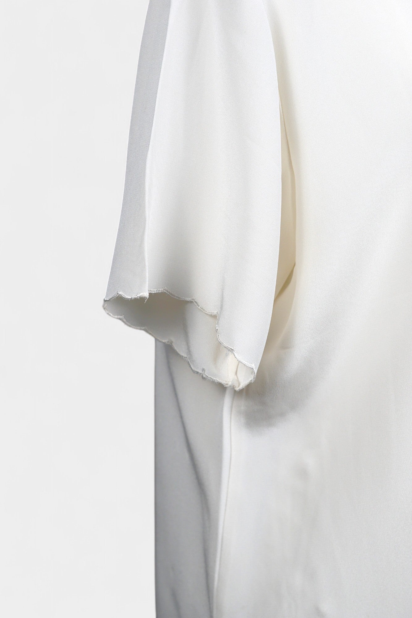 Cream silk short-sleeve blouse featuring pink floral embroidery and scalloped edges