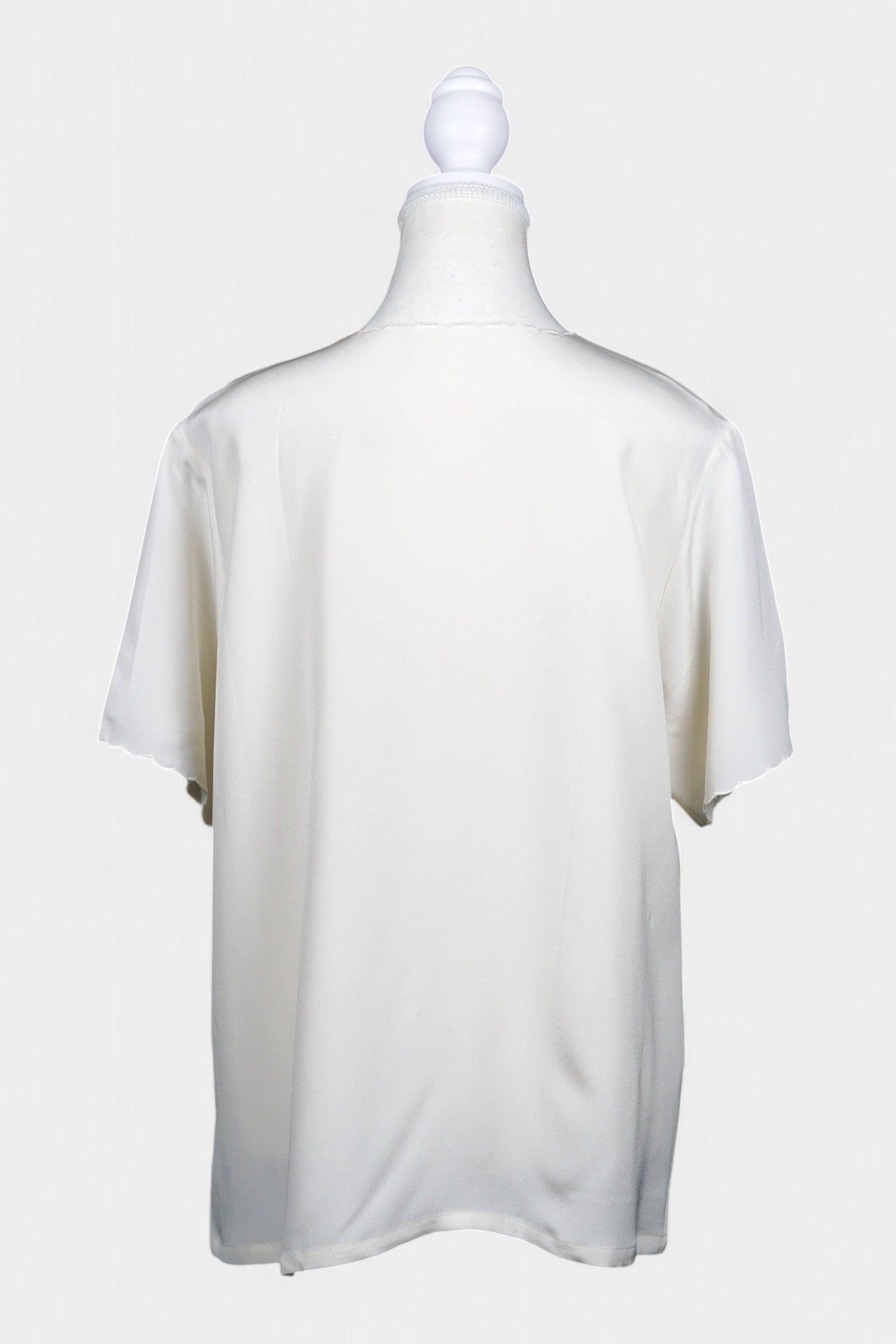 Cream silk short-sleeve blouse featuring pink floral embroidery and scalloped edges