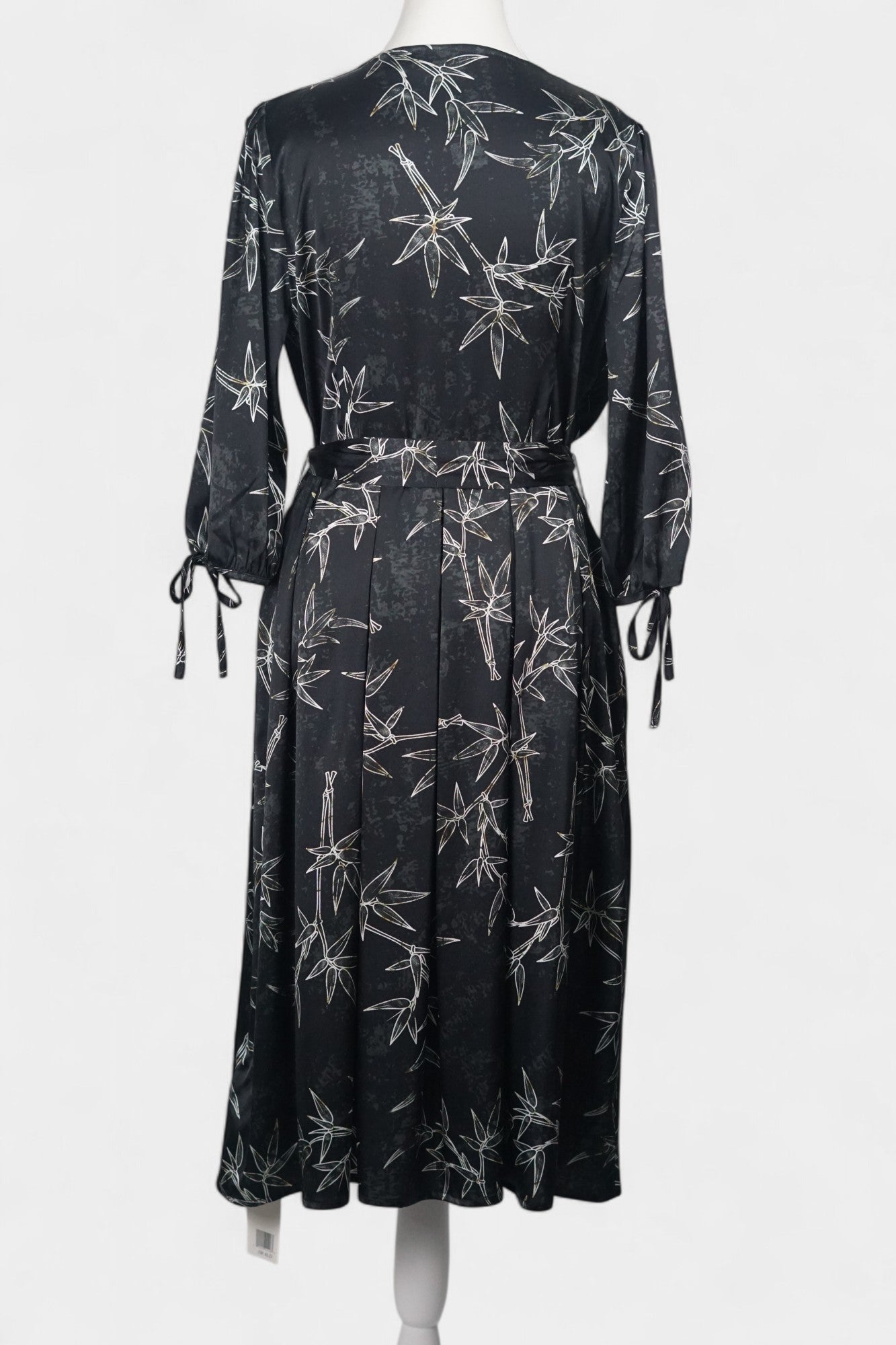 Women's black Gambiered Guangdong Gauze wrap dress with white bamboo leaf print and tie-cuff sleeves.