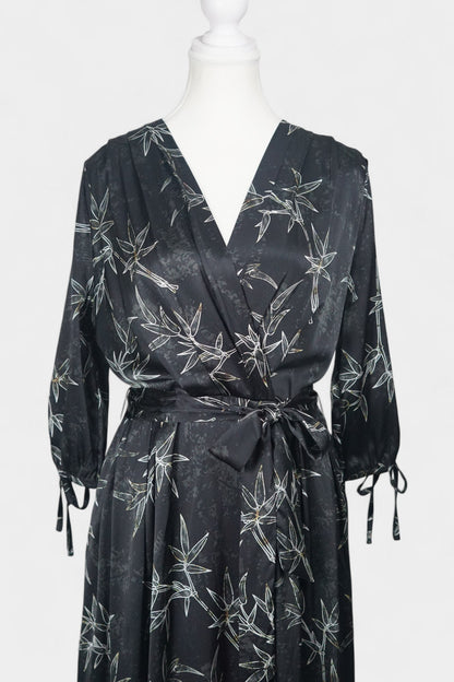 Women's black Gambiered Guangdong Gauze wrap dress with white bamboo leaf print and tie-cuff sleeves.