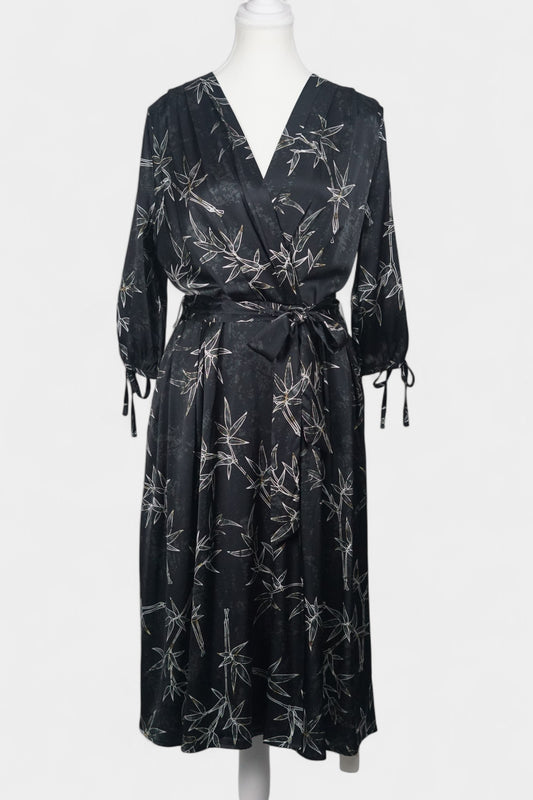 Women's black Gambiered Guangdong Gauze wrap dress with white bamboo leaf print and tie-cuff sleeves.