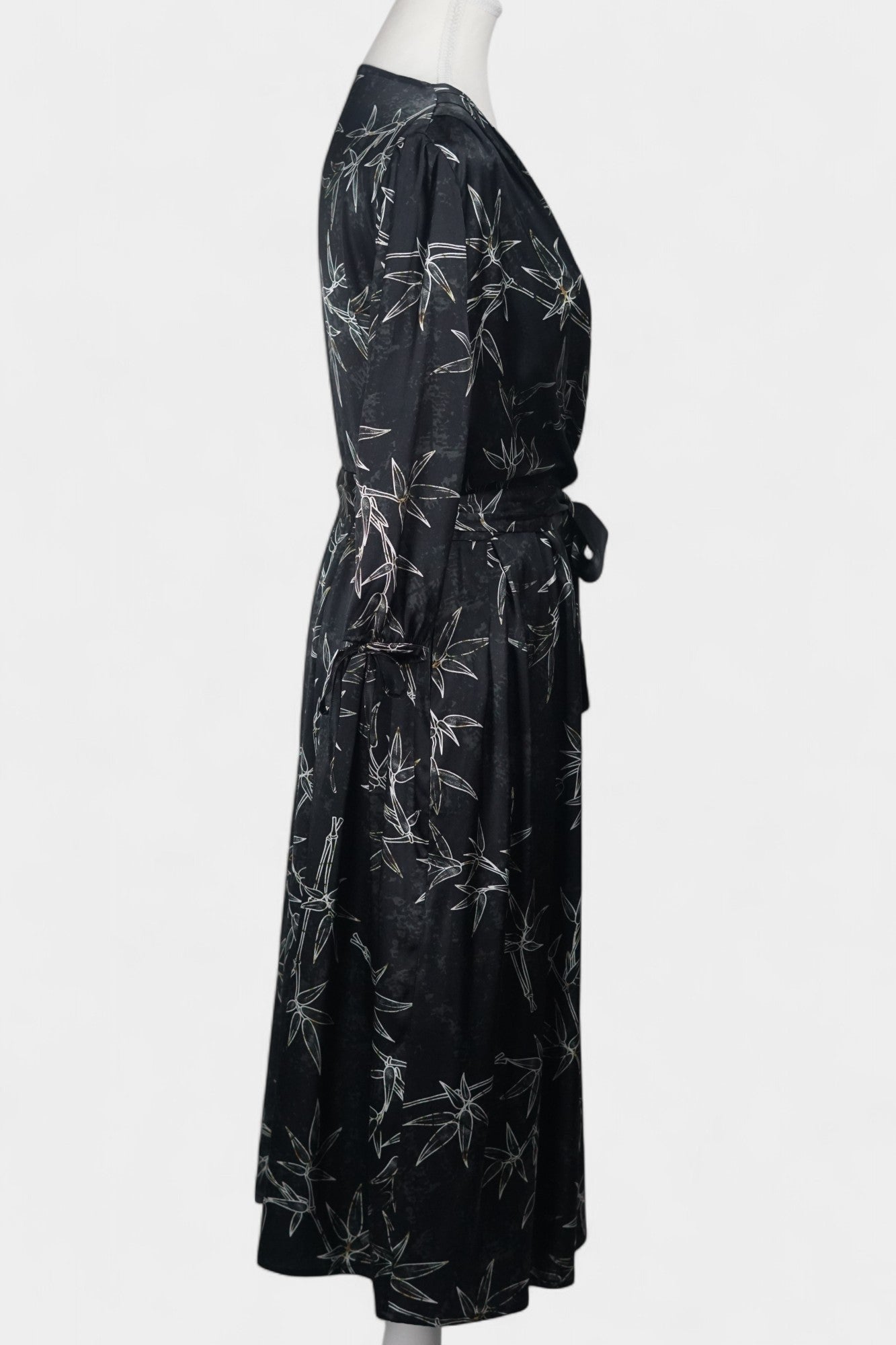 Women's black Gambiered Guangdong Gauze wrap dress with white bamboo leaf print and tie-cuff sleeves.