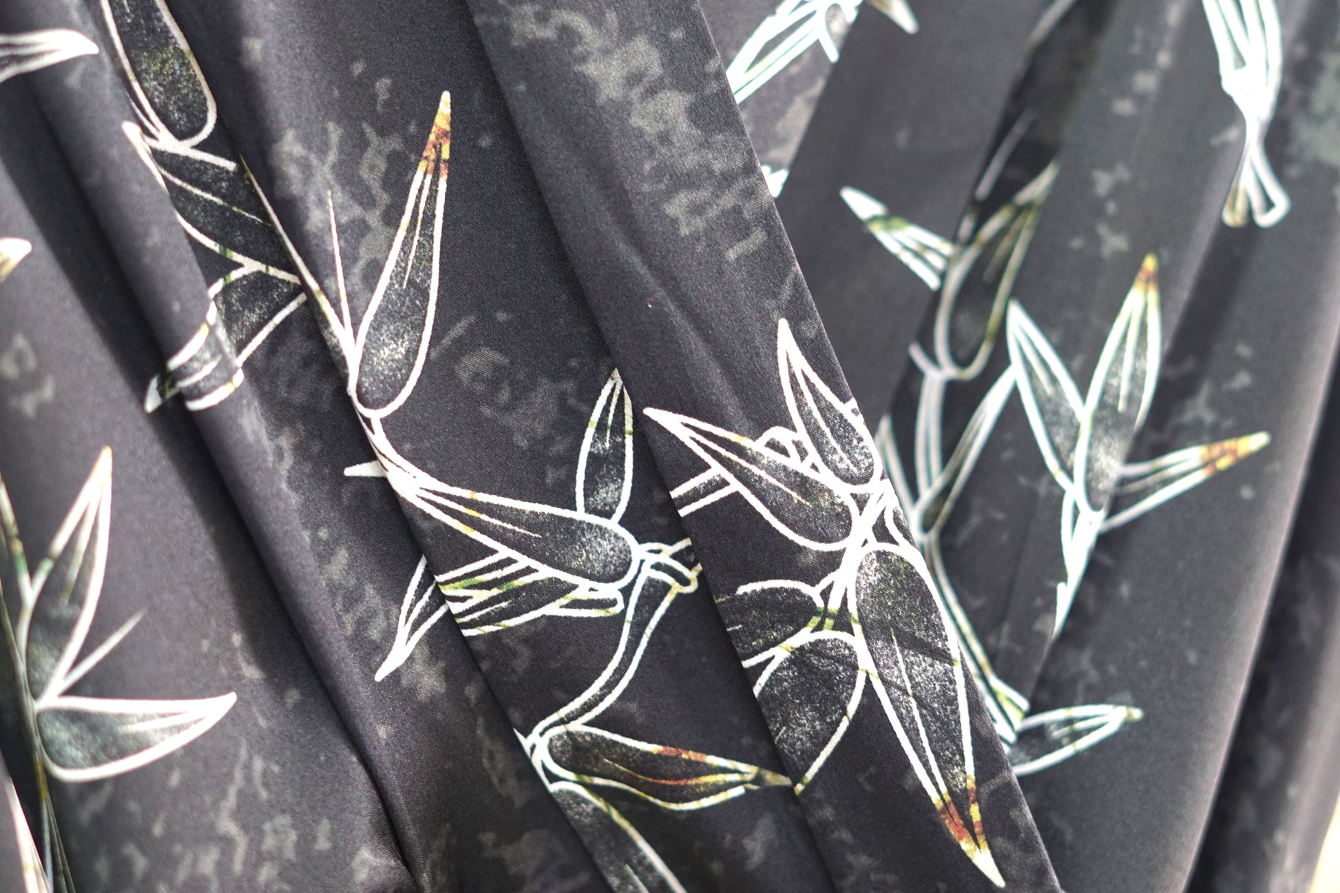 Women's black Gambiered Guangdong Gauze wrap dress with white bamboo leaf print and tie-cuff sleeves.