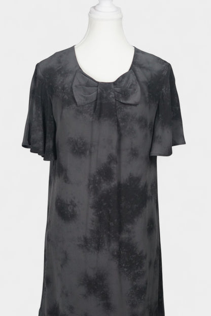 Women's black and grey patterned silk dress with a bow neckline and short flutter sleeves on a mannequin