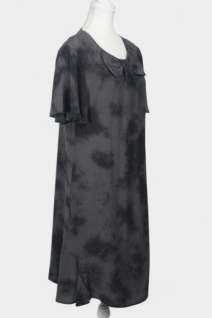 Women's black and grey patterned silk dress with a bow neckline and short flutter sleeves on a mannequin