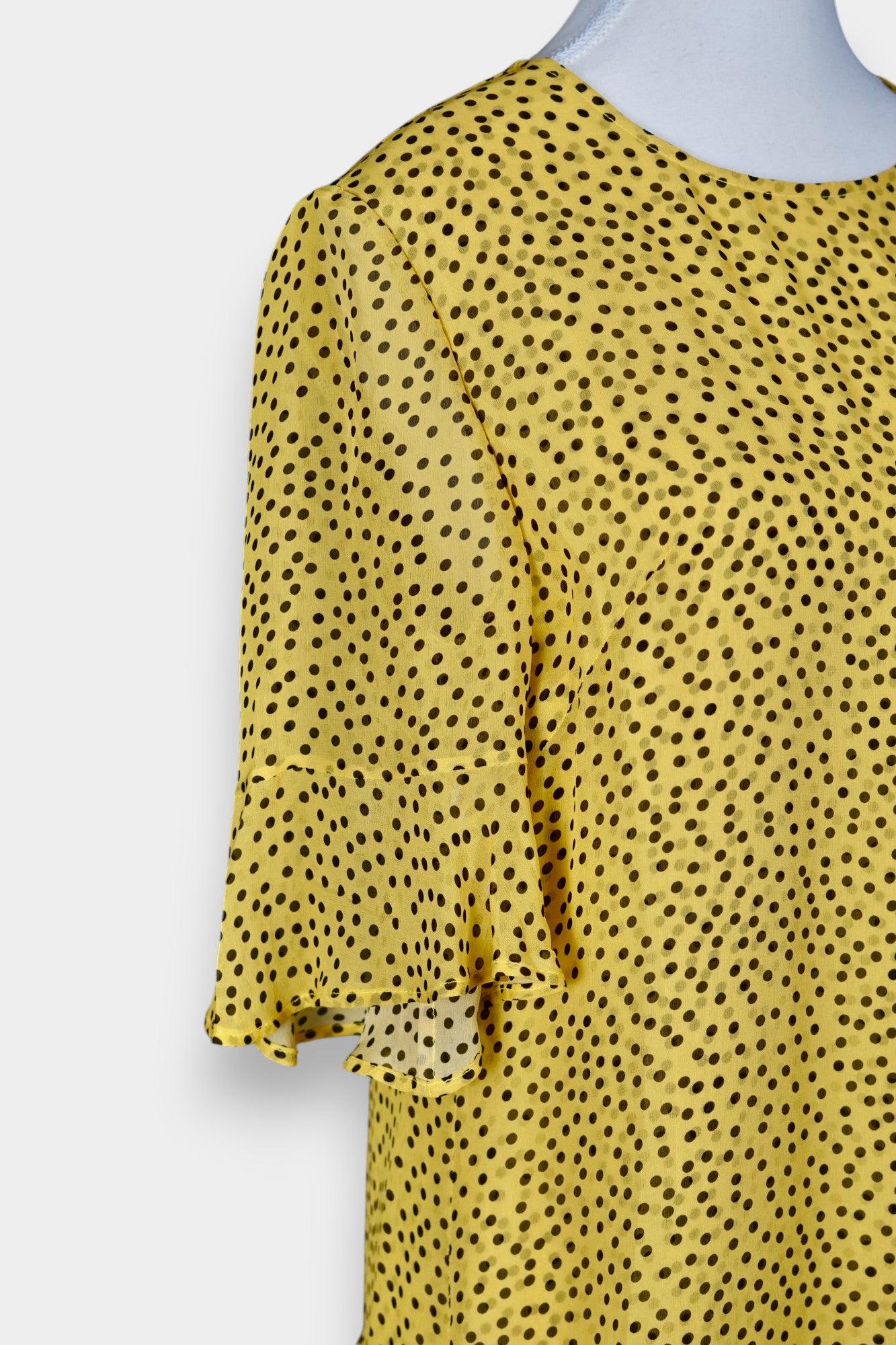 Women's yellow silk dress with black polka dots, featuring elbow-length ruffled sleeves and a gathered drop-waist hem.