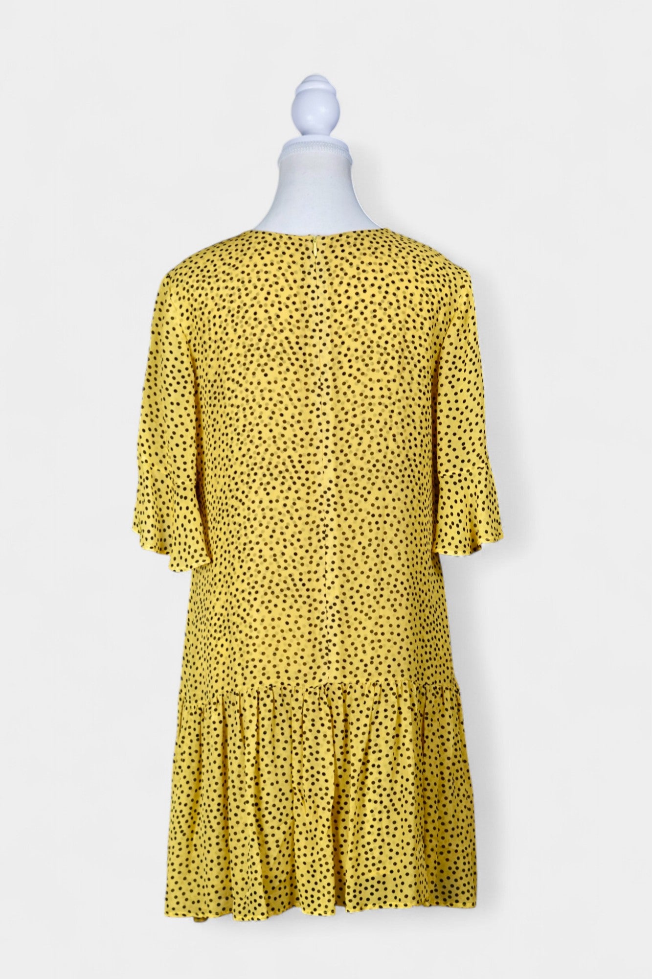 Women's yellow silk dress with black polka dots, featuring elbow-length ruffled sleeves and a gathered drop-waist hem.