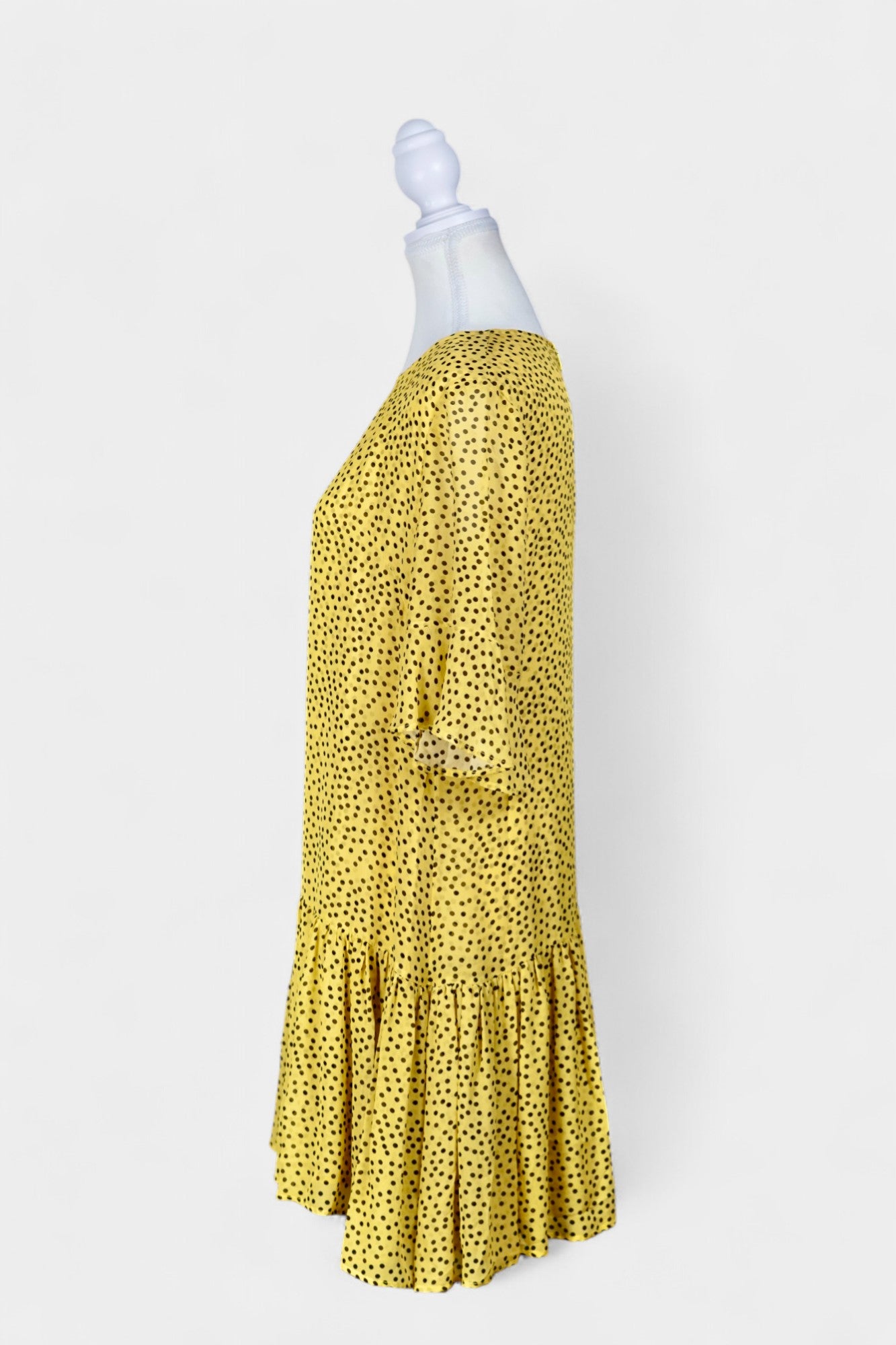 Women's yellow silk dress with black polka dots, featuring elbow-length ruffled sleeves and a gathered drop-waist hem.