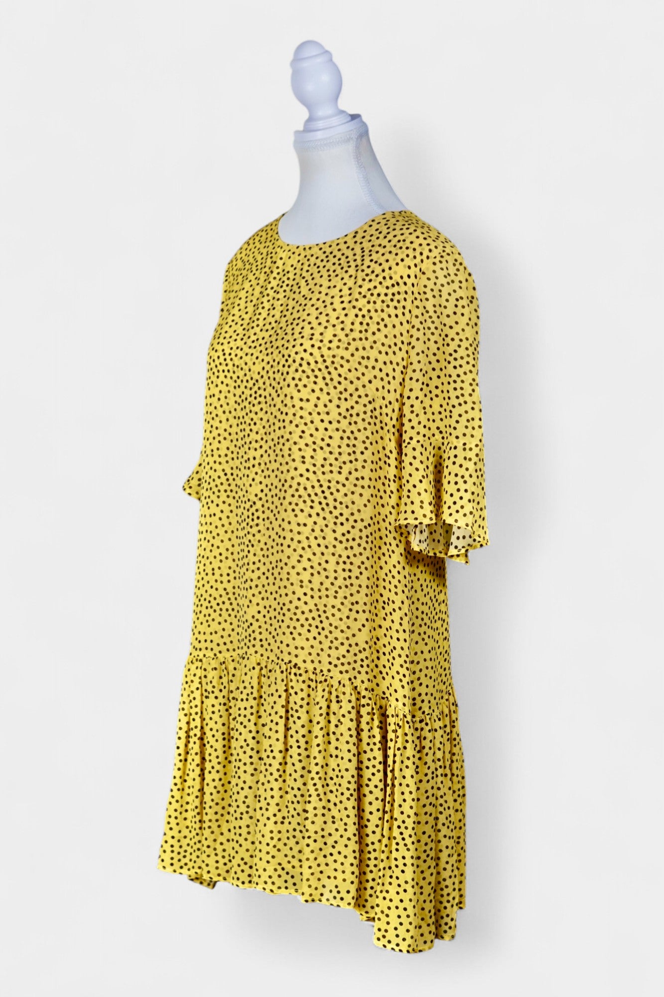 Women's yellow silk dress with black polka dots, featuring elbow-length ruffled sleeves and a gathered drop-waist hem.