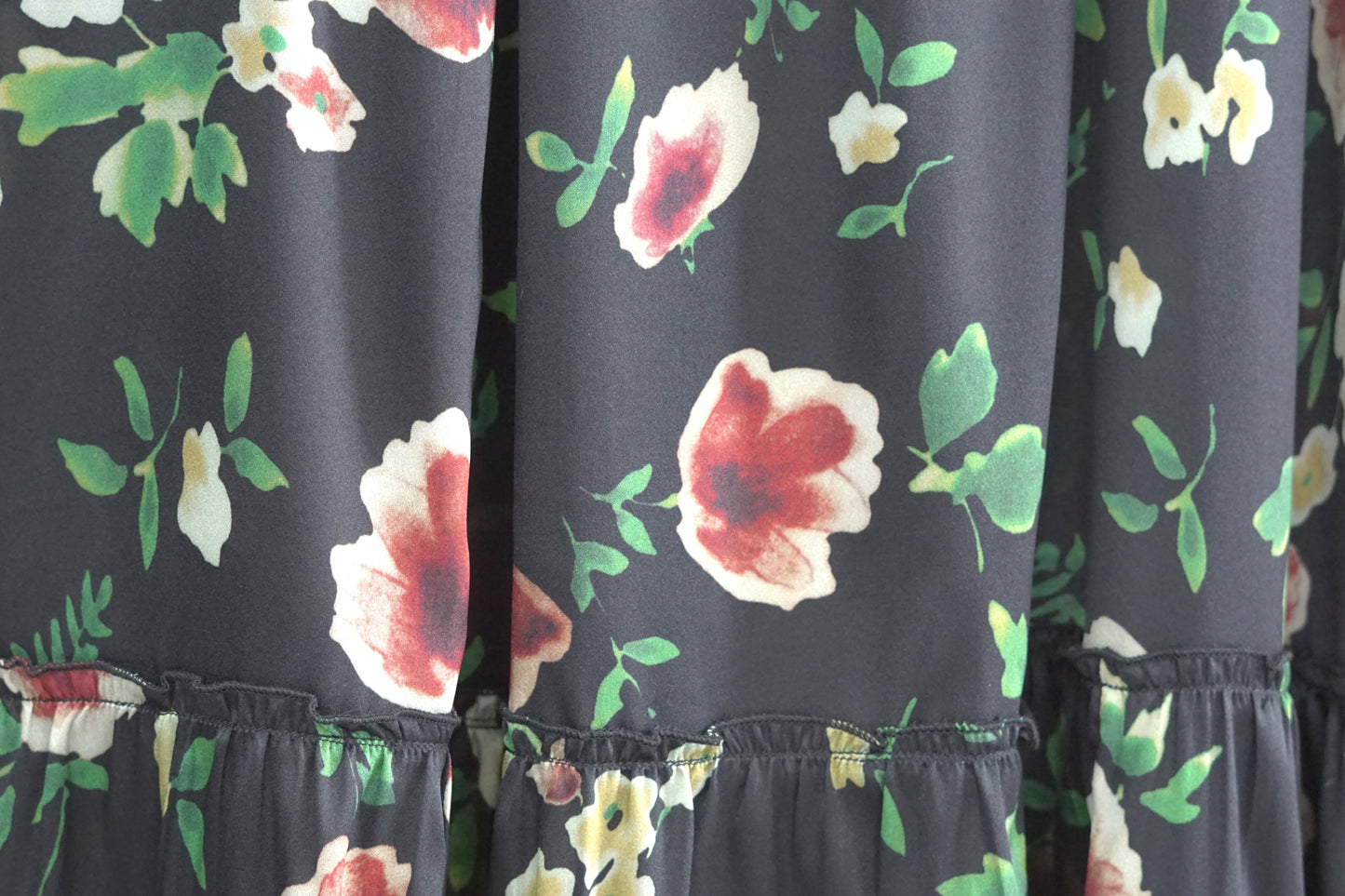 Black floral silk midi skirt with elastic waistband and tiered ruffle hem