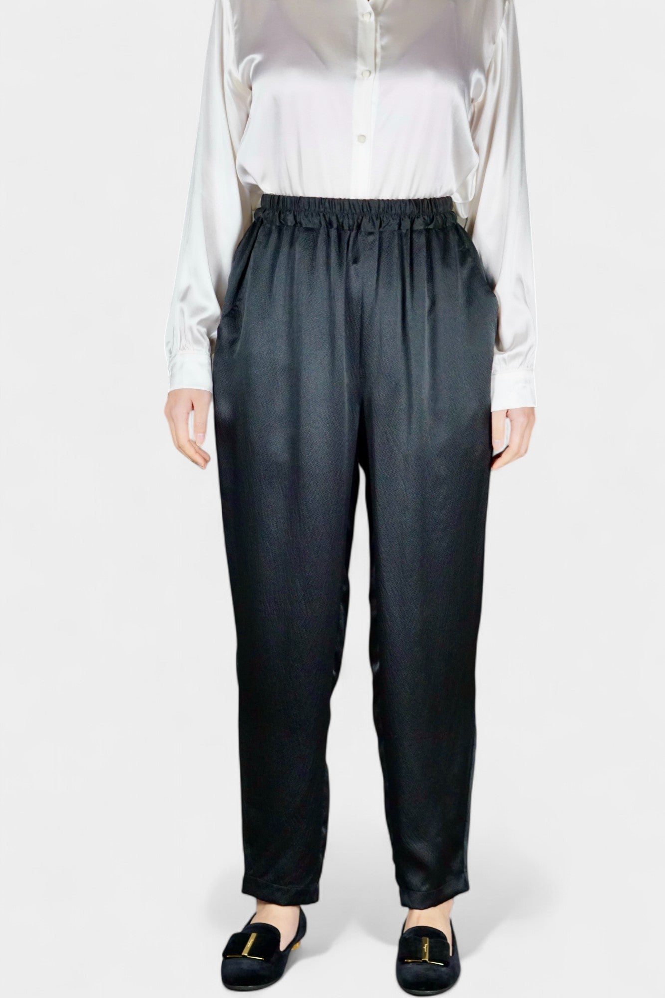 Black Mulberry silk trousers featuring elastic waistband and tapered leg design.