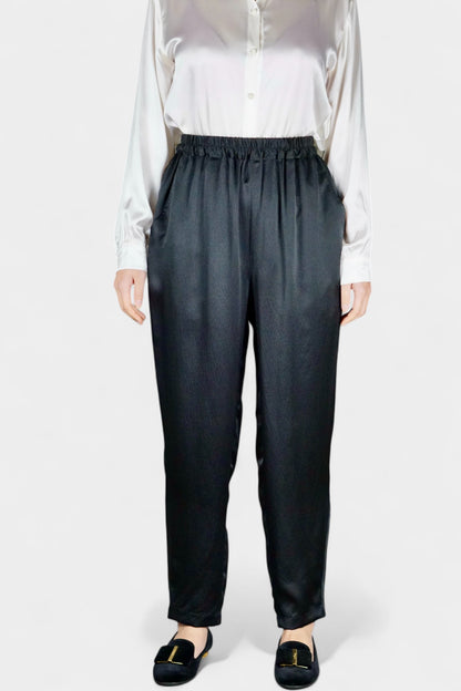 Black Mulberry silk trousers featuring elastic waistband and tapered leg design.