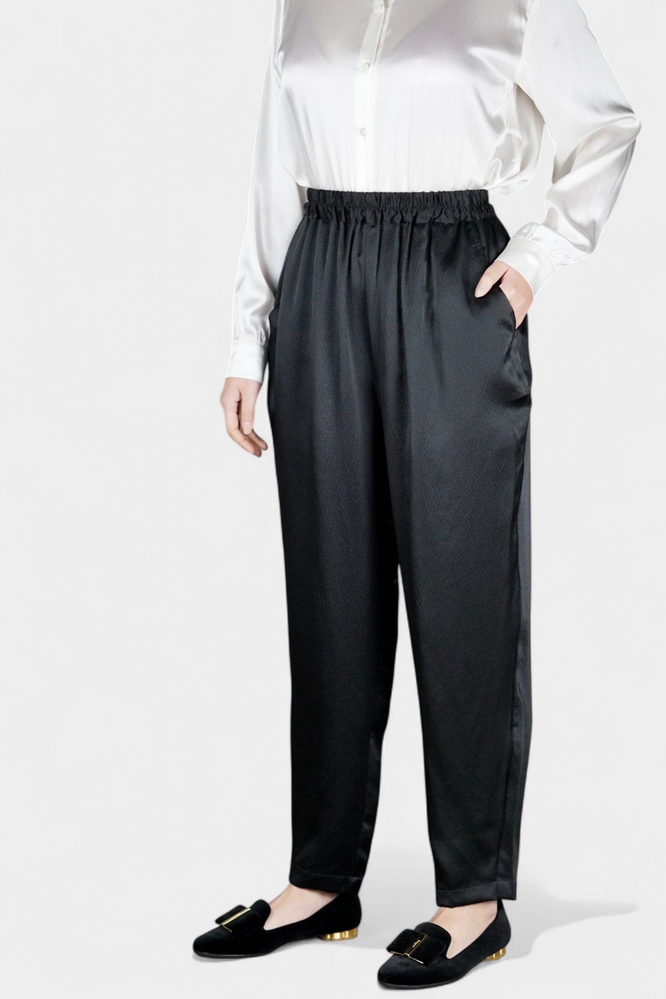 Black Mulberry silk trousers featuring elastic waistband and tapered leg design.