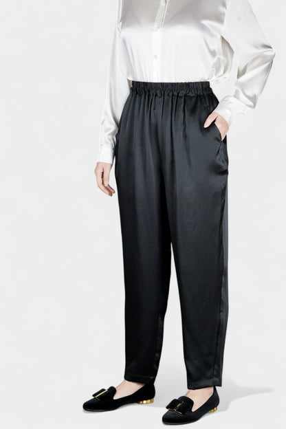 Black Mulberry silk trousers featuring elastic waistband and tapered leg design.