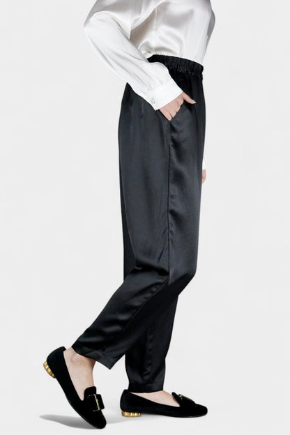 Black Mulberry silk trousers featuring elastic waistband and tapered leg design.