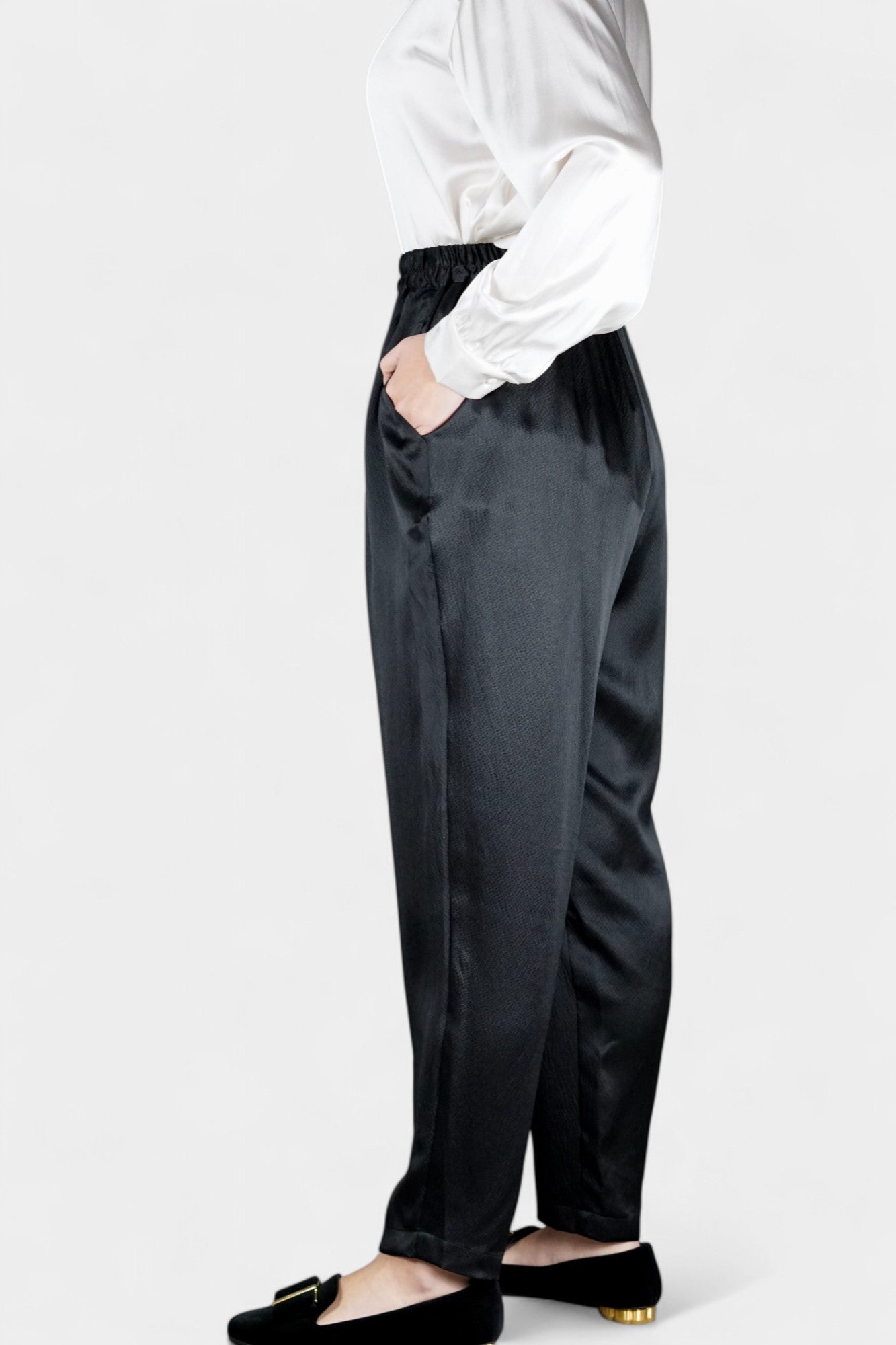 Black Mulberry silk trousers featuring elastic waistband and tapered leg design.
