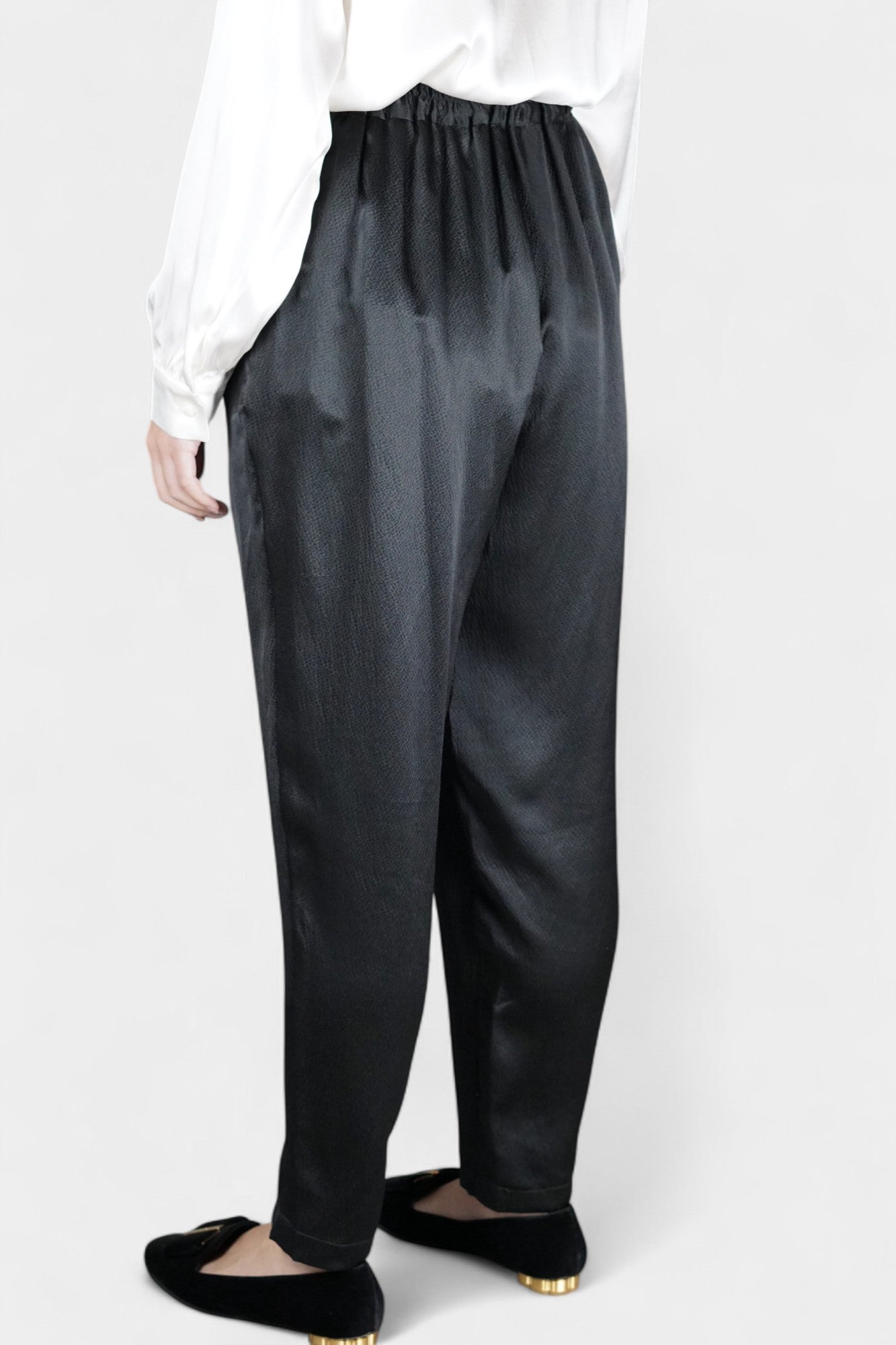 Black Mulberry silk trousers featuring elastic waistband and tapered leg design.