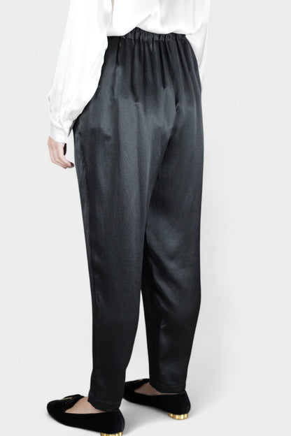 Black Mulberry silk trousers featuring elastic waistband and tapered leg design.