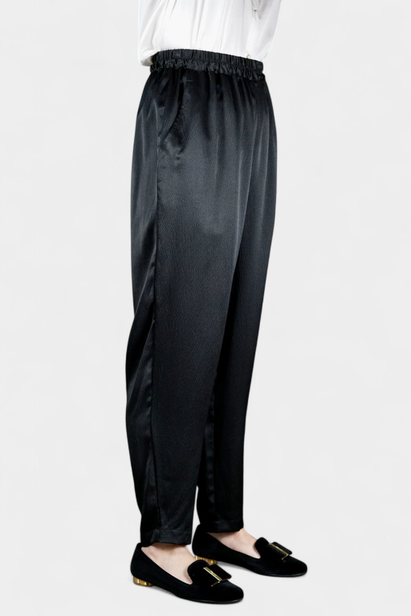 Black Mulberry silk trousers featuring elastic waistband and tapered leg design.