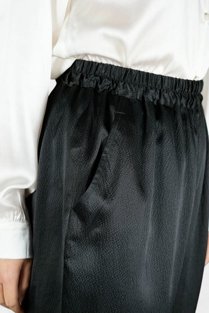 Black Mulberry silk trousers featuring elastic waistband and tapered leg design.