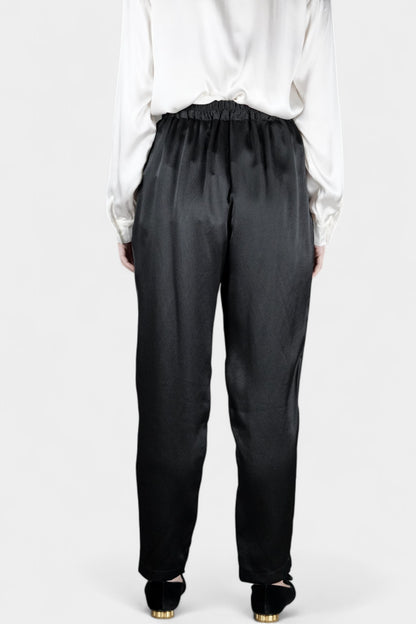 Black Mulberry silk trousers featuring elastic waistband and tapered leg design.