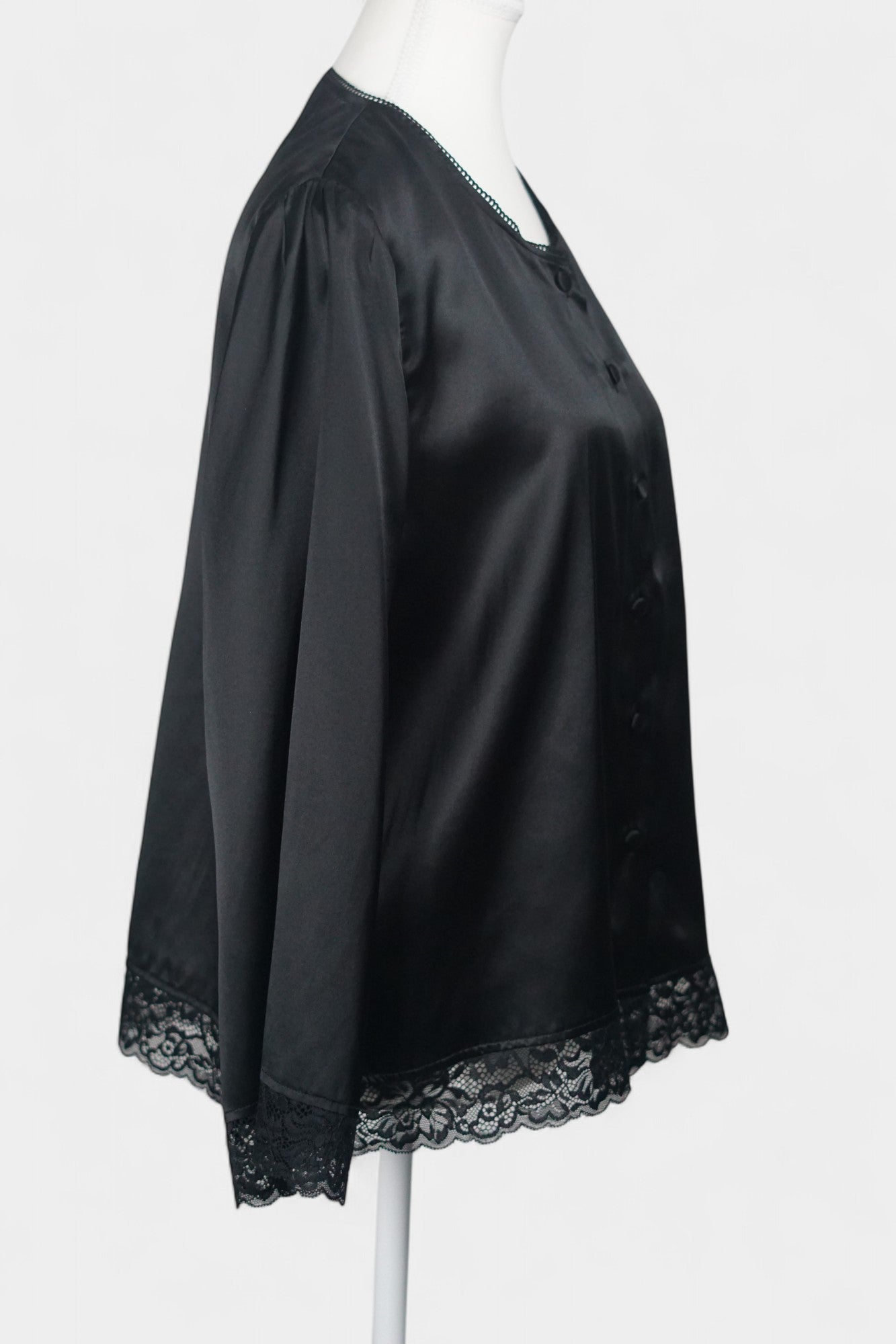 Black silk jacket featuring delicate lace trim on cuffs and hem, with button-down front