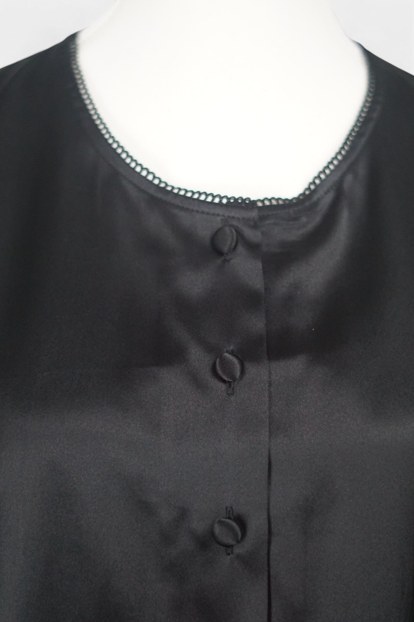 Black silk jacket featuring delicate lace trim on cuffs and hem, with button-down front