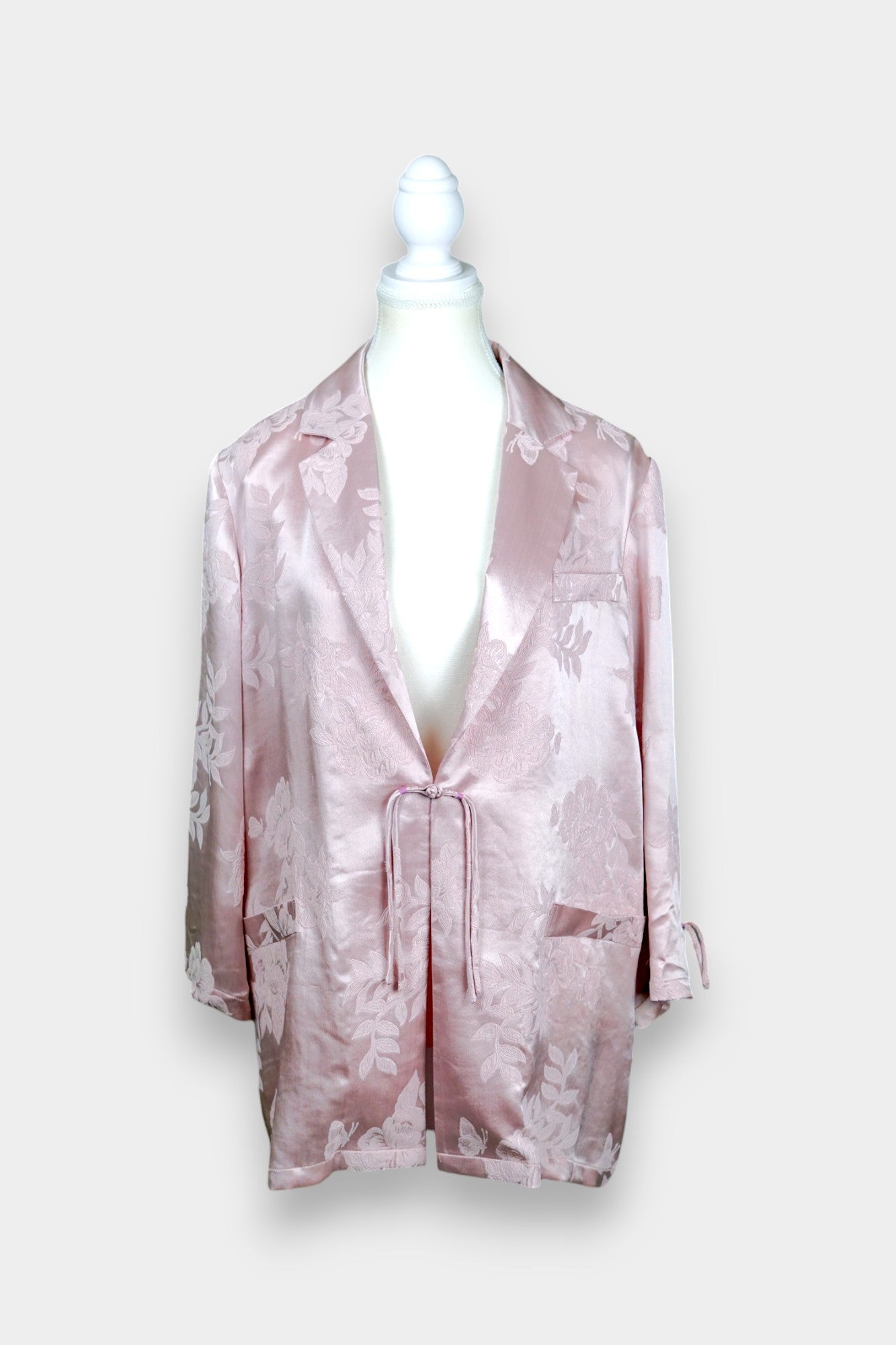 Dusty pink silk jacquard blazer featuring floral pattern and ribbon tie-front closure