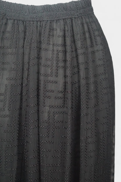 Semi-sheer noir skirt with intricate geometric cutouts, featuring a comfortable elastic waistband and a tiered flounce hem.