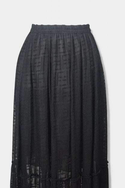 Semi-sheer noir skirt with intricate geometric cutouts, featuring a comfortable elastic waistband and a tiered flounce hem.