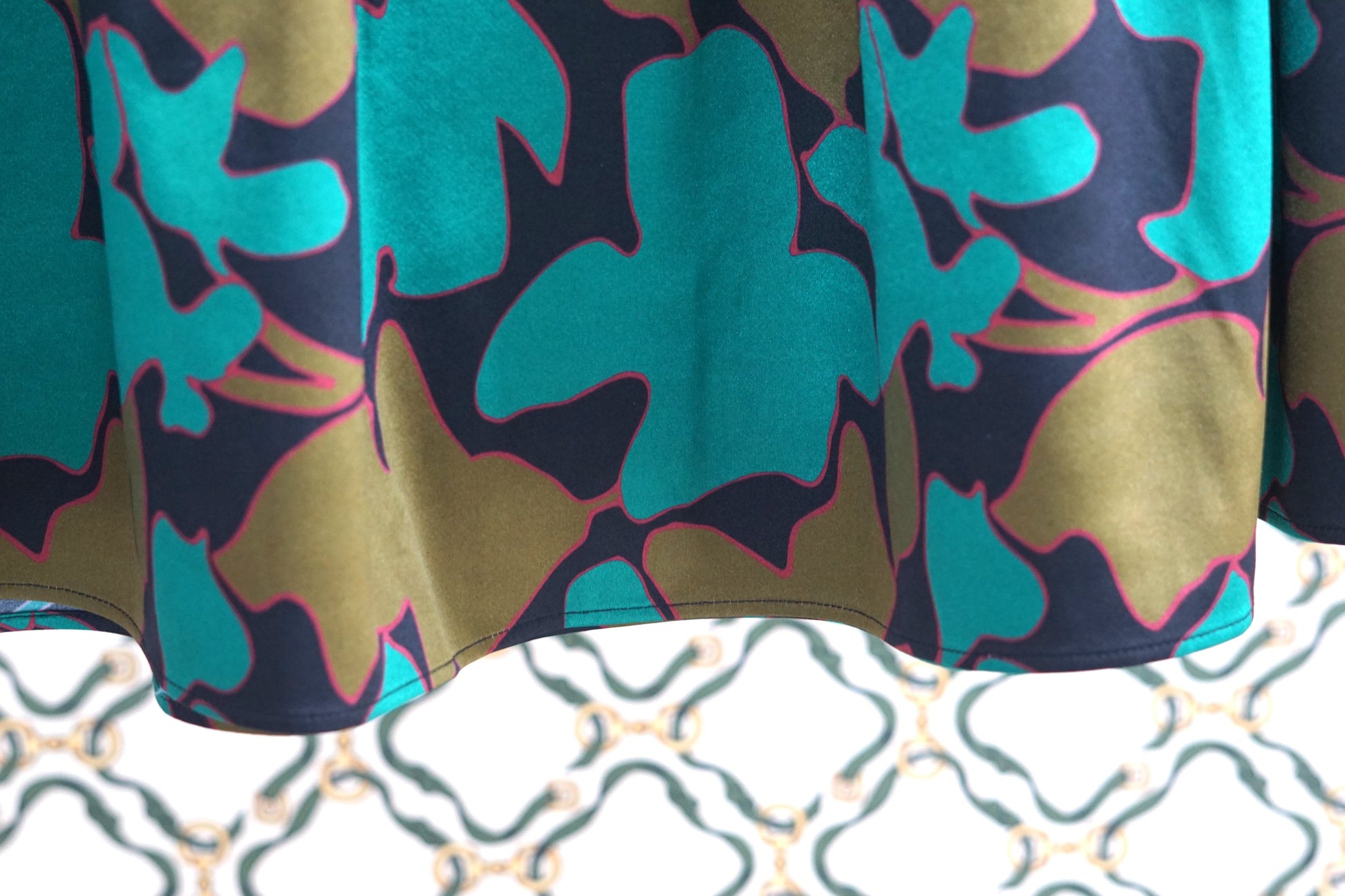 Flowy A-line skirt with smocked waist in lustrous green and copper abstract design
