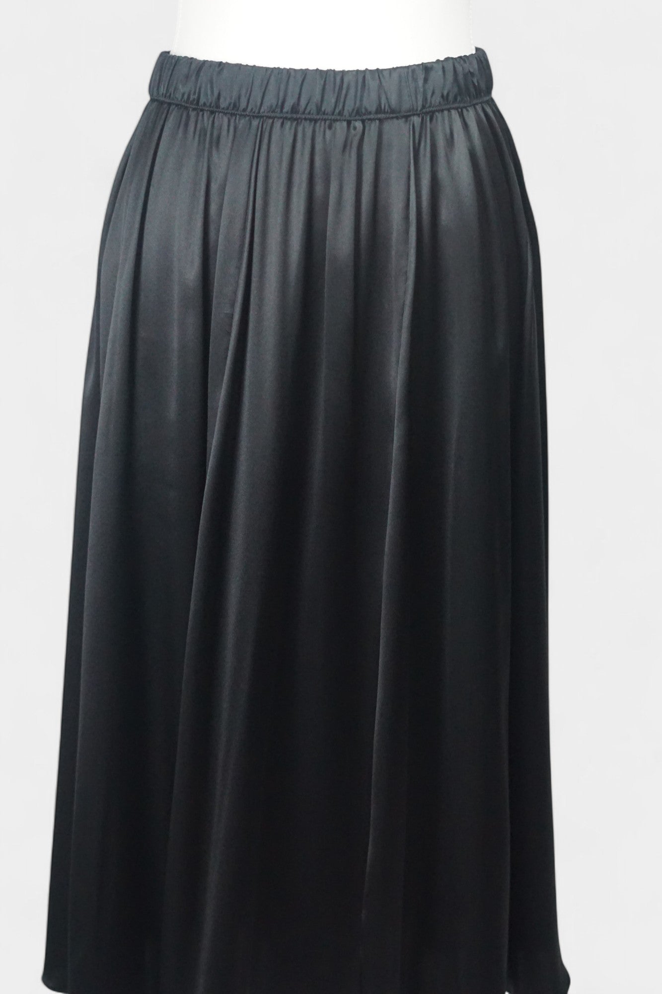 Solid black silk midi skirt featuring a comfortable elastic waistband and gathered A-line silhouette