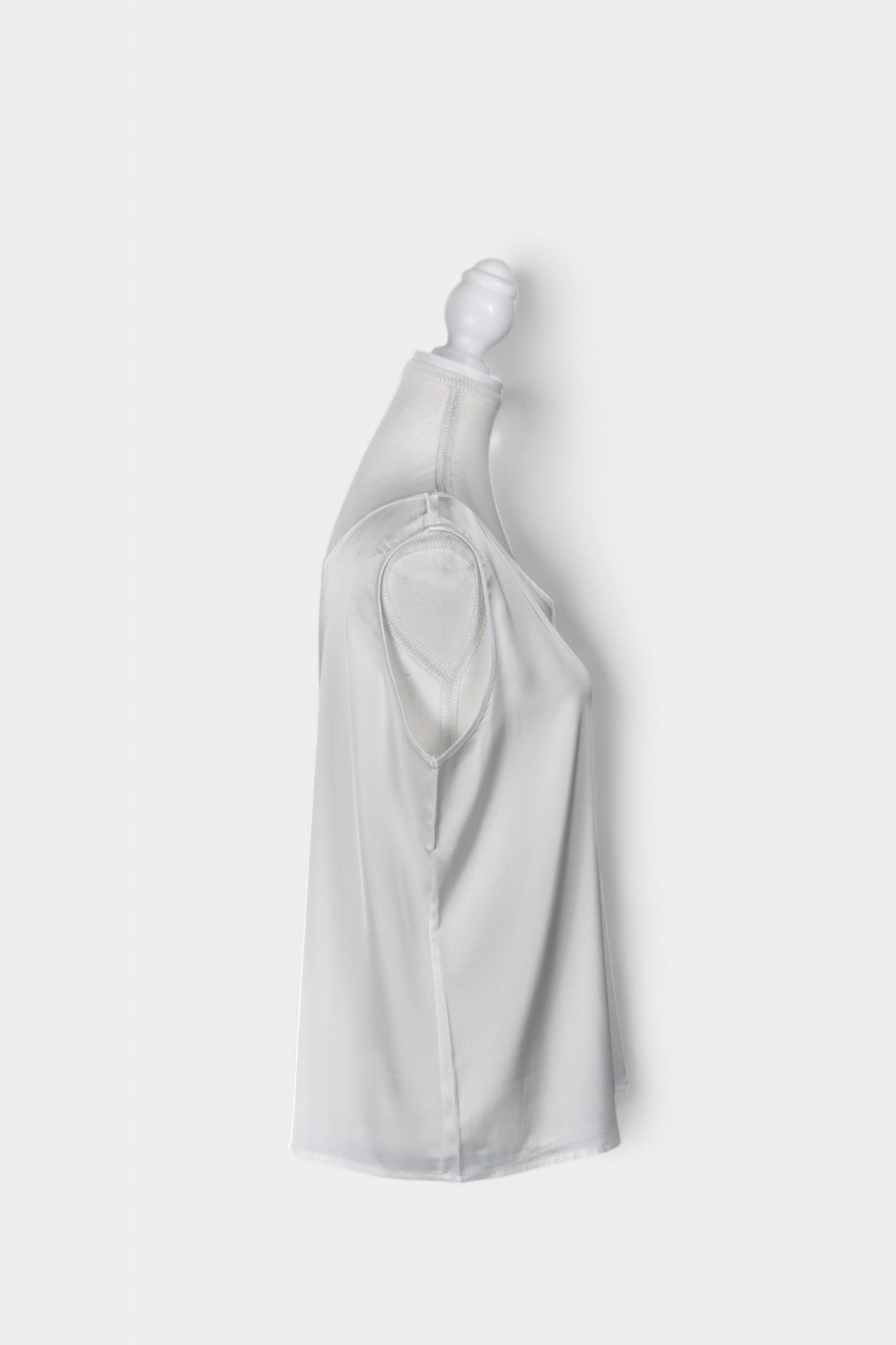 Women's white sleeveless silk top with a scoop neckline on a mannequin.