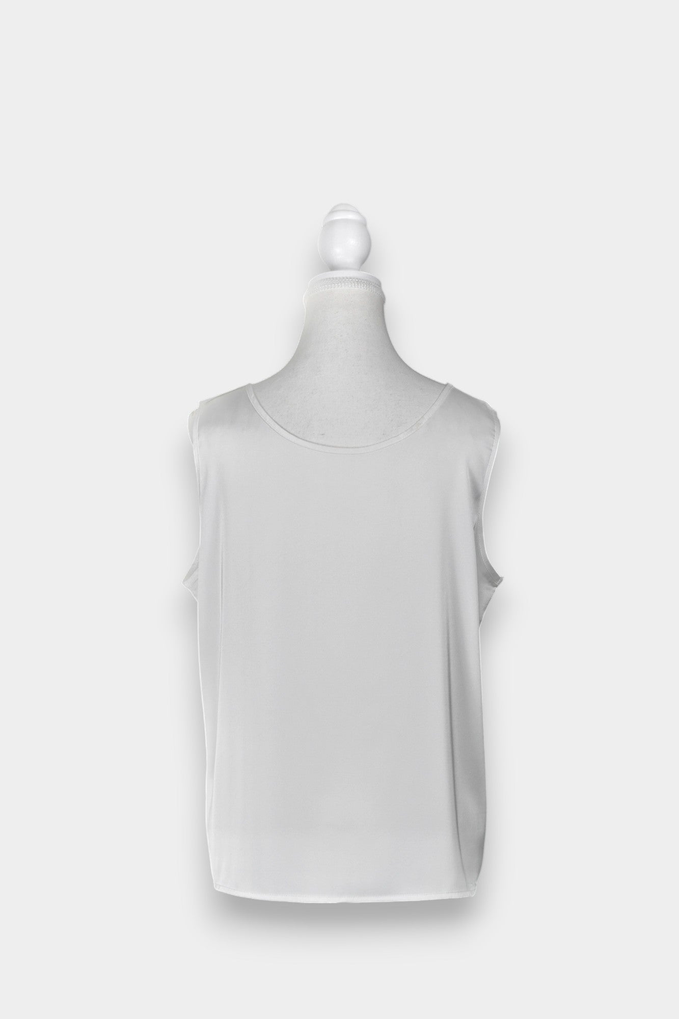 Women's white sleeveless silk top with a scoop neckline on a mannequin.