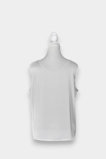 Women's white sleeveless silk top with a scoop neckline on a mannequin.