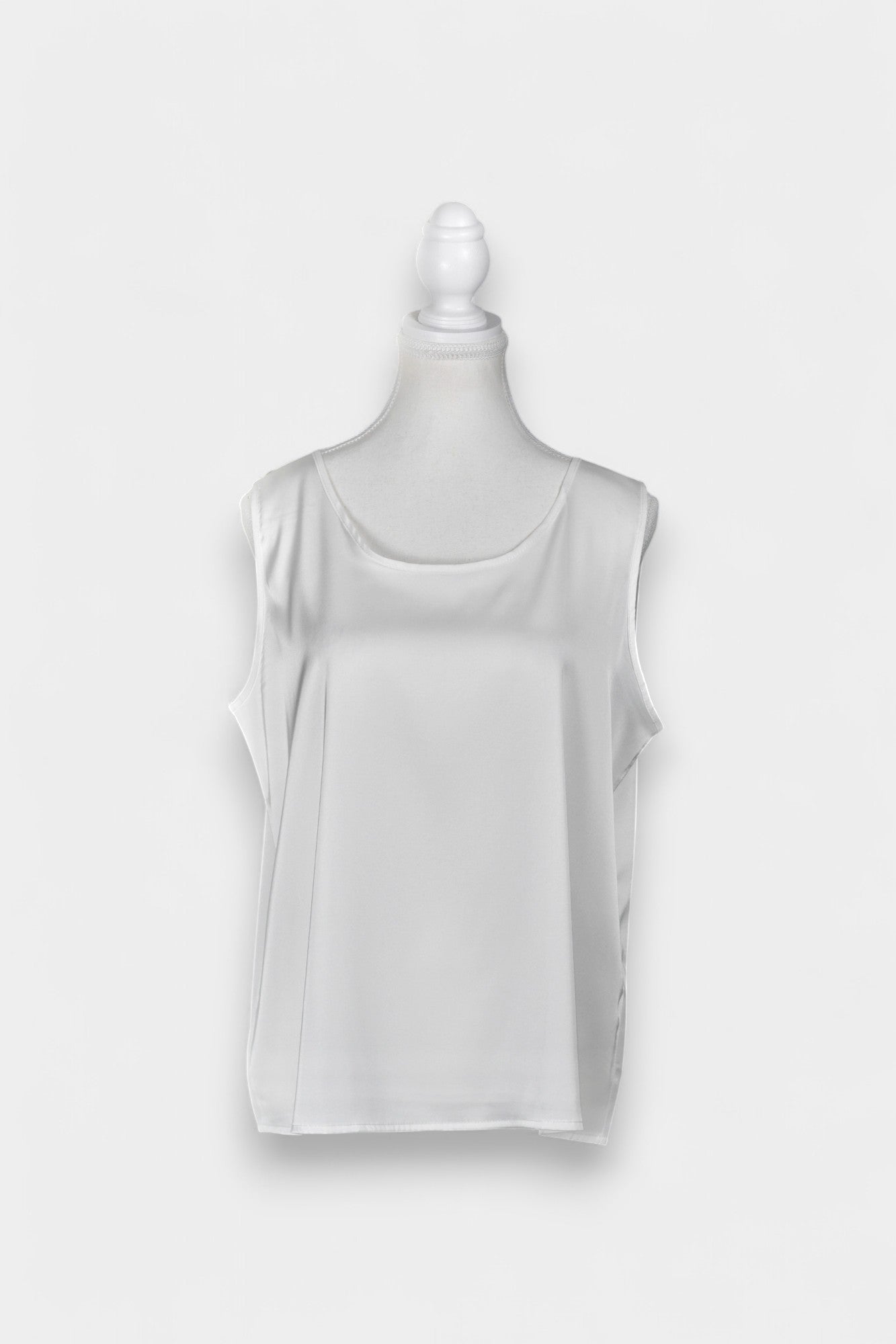 Women's white sleeveless silk top with a scoop neckline on a mannequin.