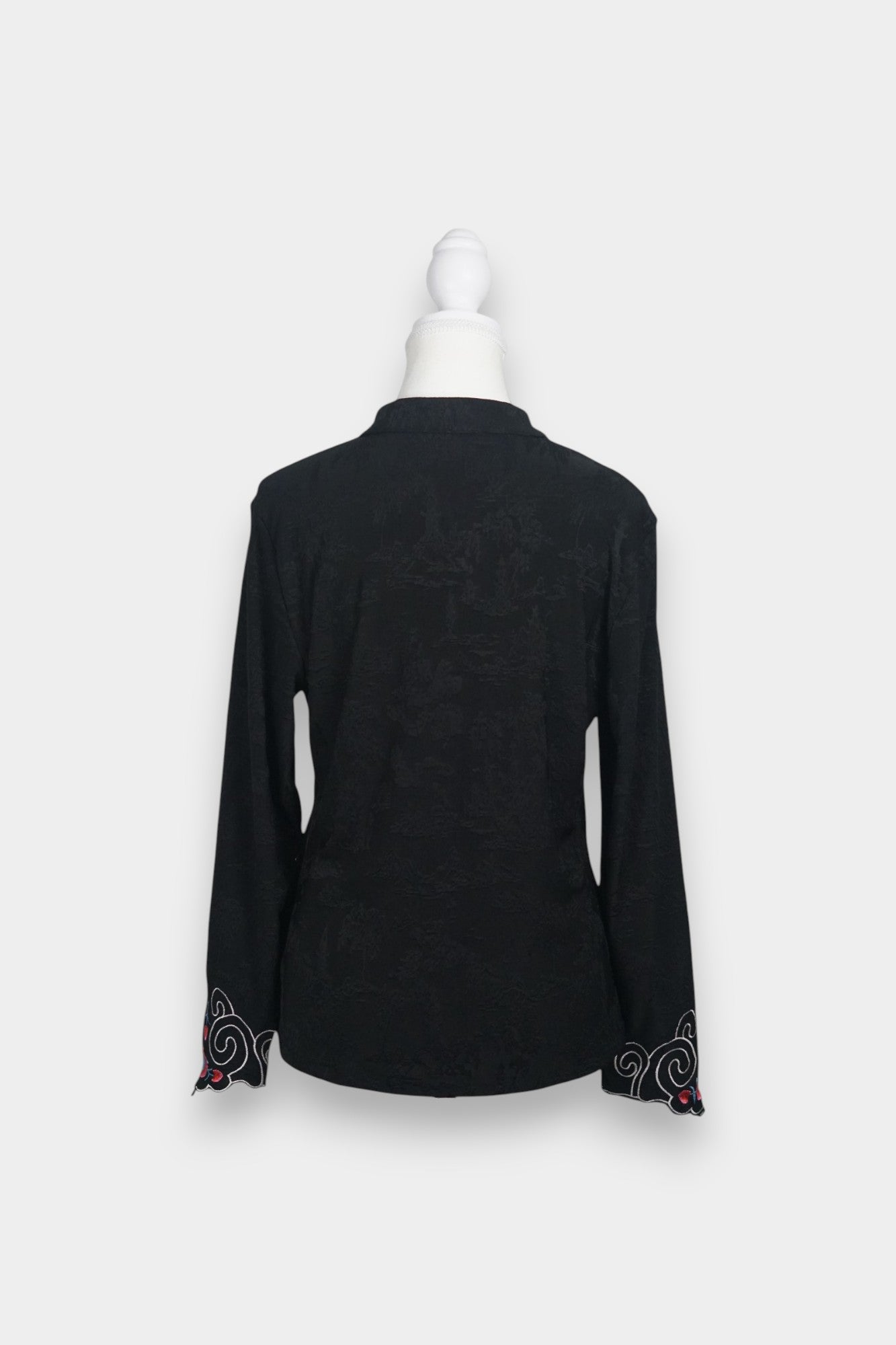 Long sleeve black mandarin collar blouse made from silk spandex blend with embroidery details.